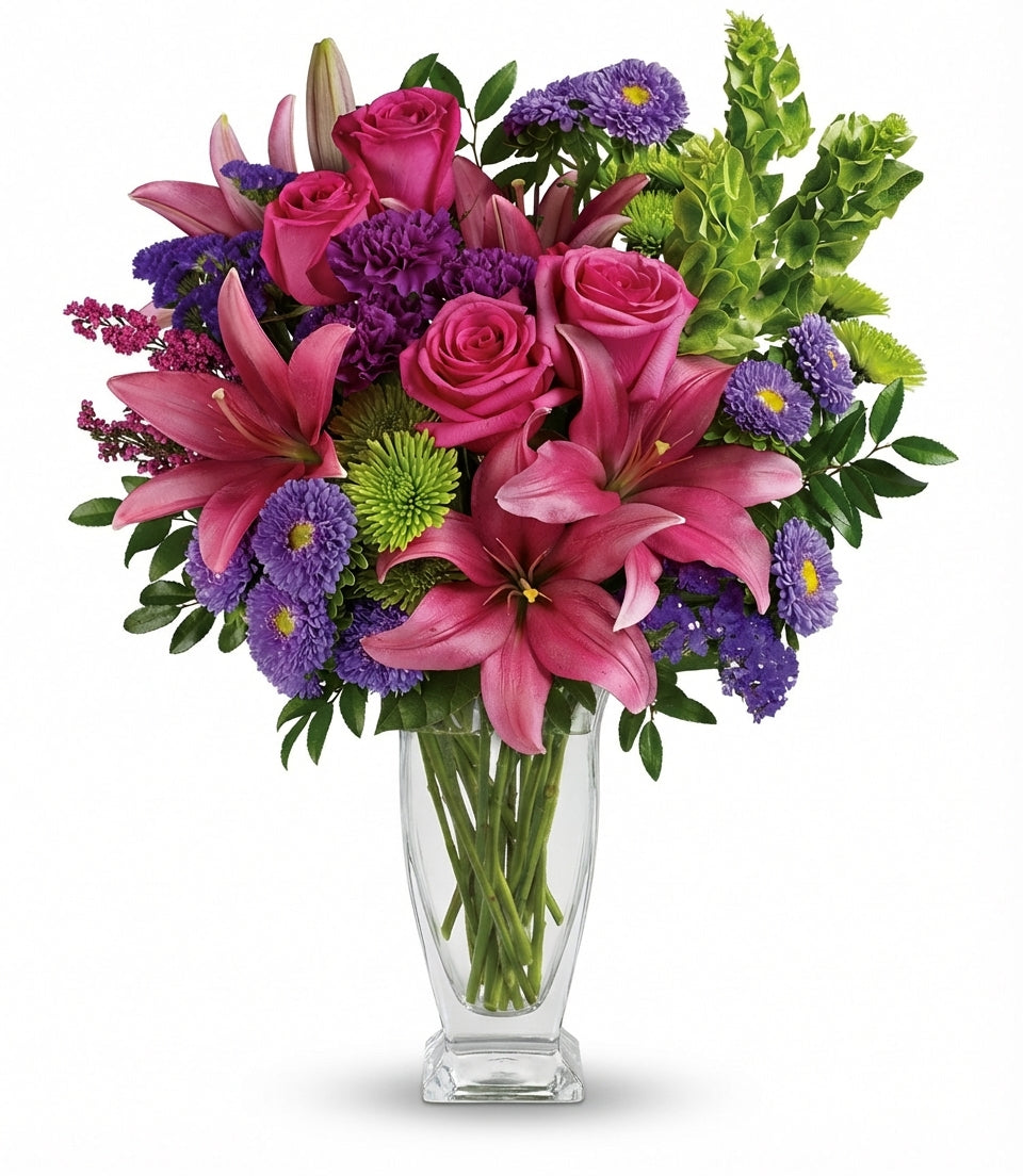 The You’re A Gem Bouquet by Fleuriste Terrafolia Flowers features a fresh, colorful mix of pink roses, asiatic lilies, purple asters, green chrysanthemums, and assorted greenery arranged in a classic glass vase.