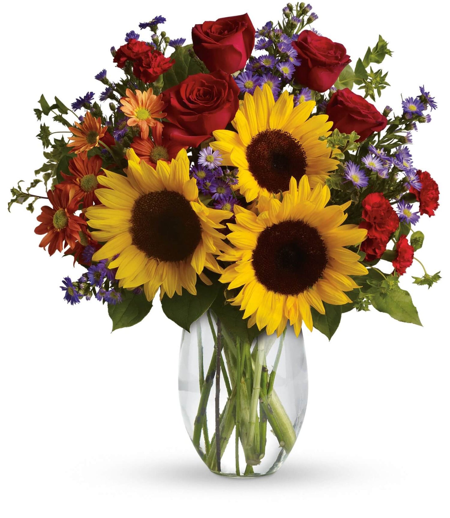 The Pure Happiness Bouquet by TF features sunflowers, red roses, orange daisies, purple fillers, and green leaves in a clear glass vase, creating a vibrant arrangement against a white background.