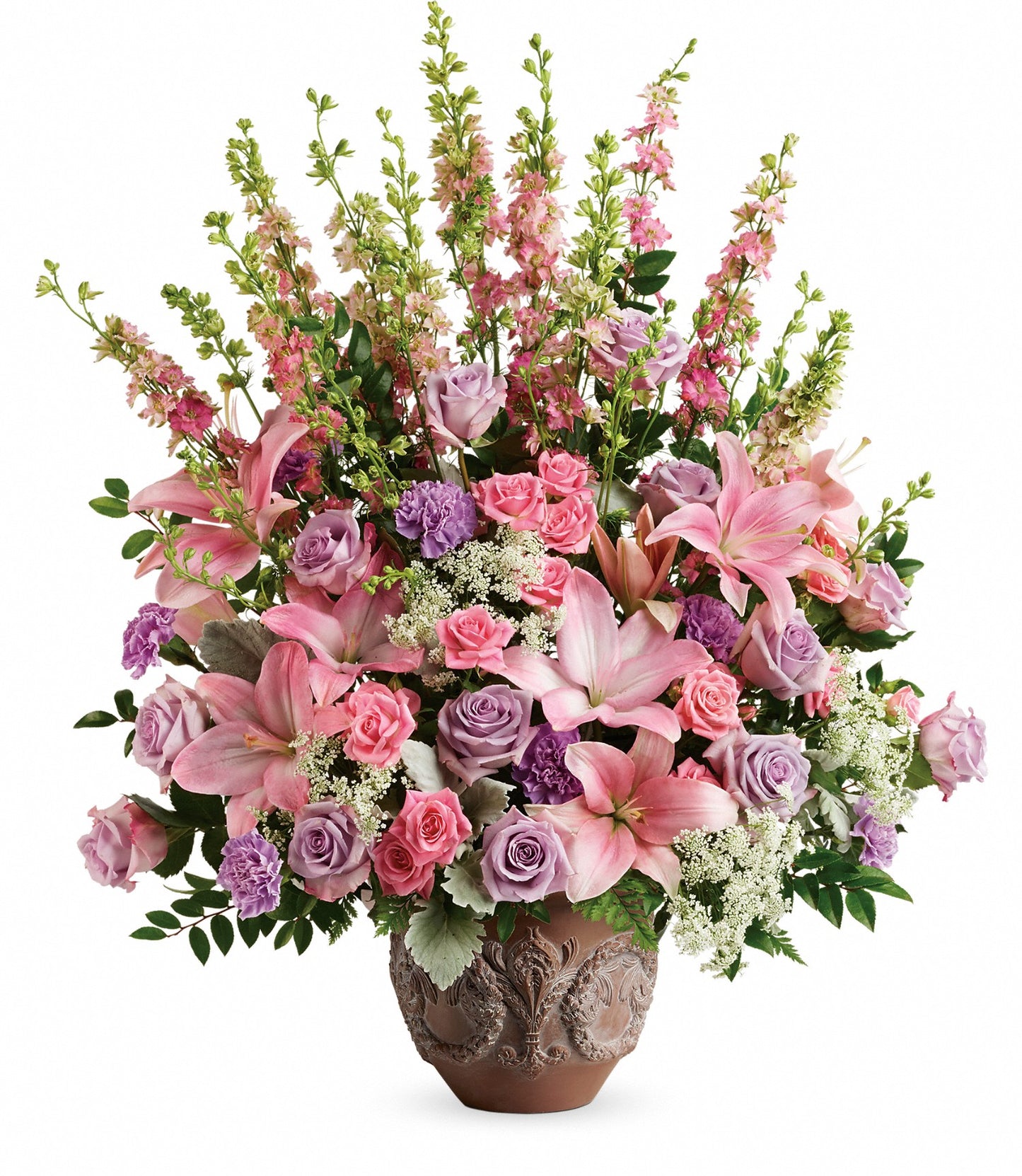 The Soft Blush Bouquet features a decorative ceramic vase filled with pink asiatic lilies, pink and lavender roses, purple carnations, and greenery for an elegant, colorful touch.