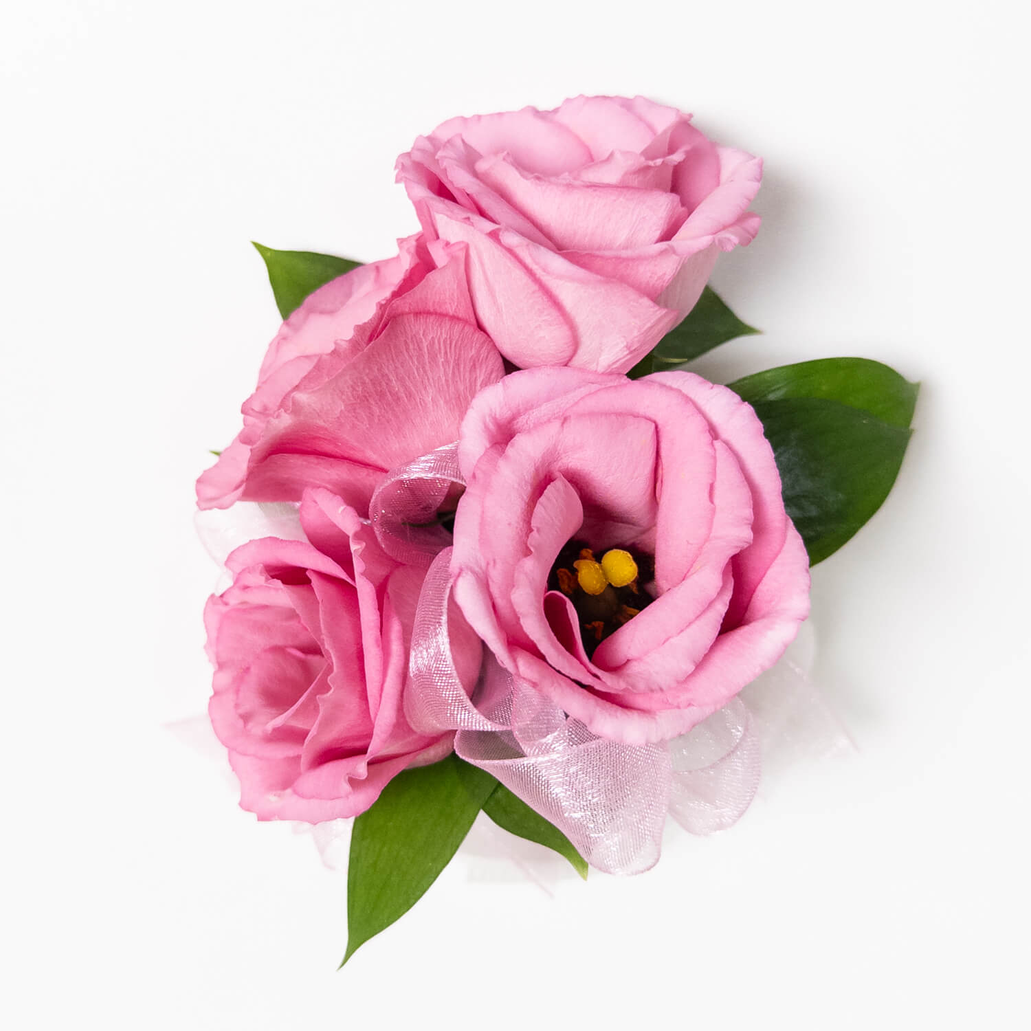 Le bracelet Blush Bloom présente trois roses roses avec des feuilles vertes et un ruban blanc transparent, disposées simplement pour une touche d'élégance - parfait pour les mariages ou les bals de fin d'année.