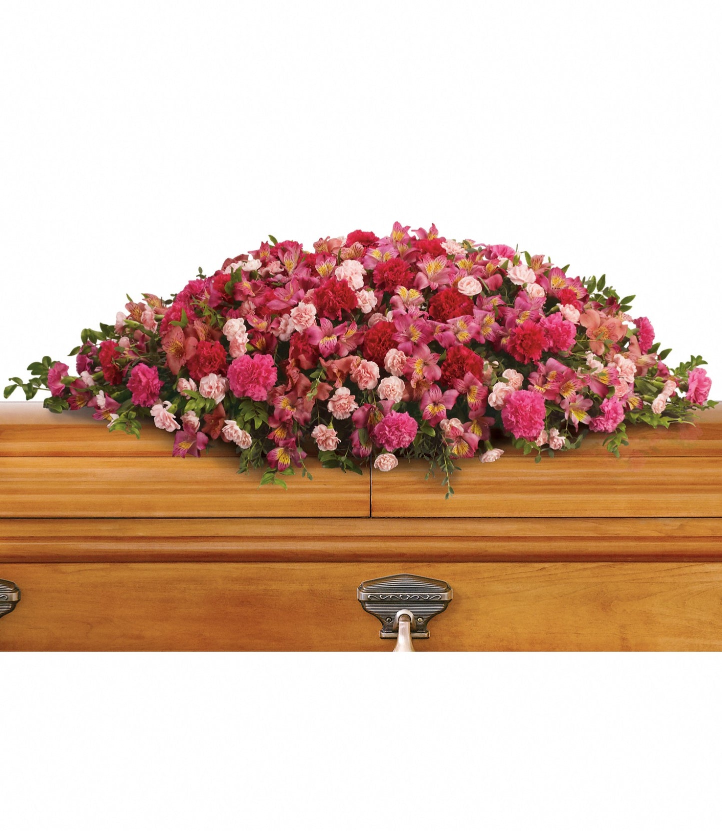 The A Life Loved Casket Spray adorns a wooden casket with silver handles, featuring a large bouquet of pink, red, and purple blooms such as dark pink alstroemeria and hot pink carnations, accented with lush greenery.