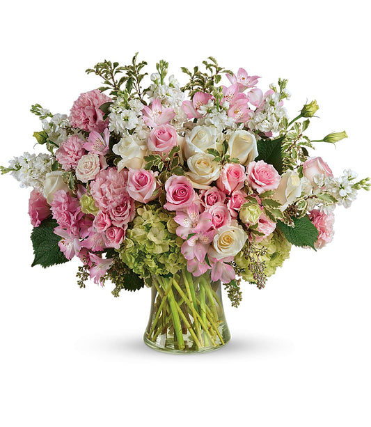 The Beautiful Love Bouquet features a large gathering vase filled with pink and white roses, light green hydrangeas, pink lilies, and assorted greenery for a fresh and elegant look.