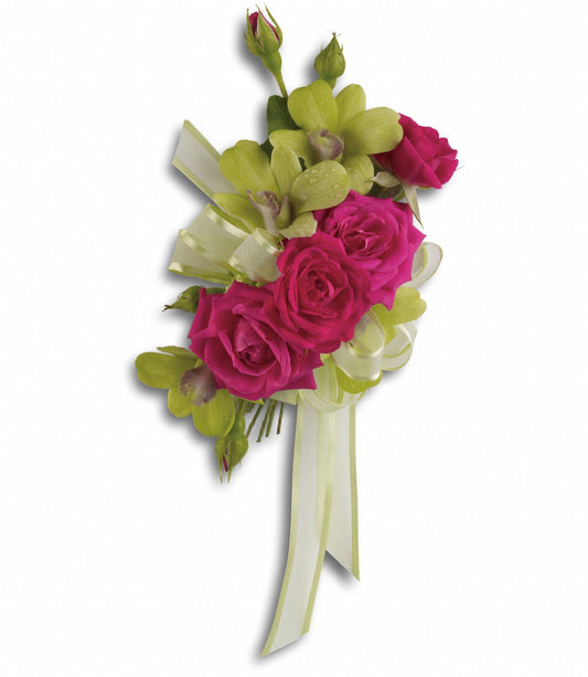 The TF Chic and Stunning Corsage features hot pink spray roses, green dendrobium orchids, small buds, and light green ribbon bows with streamers, beautifully arranged on a white background.