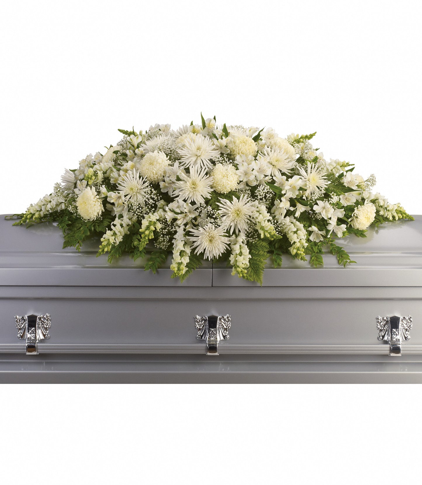 The Enduring Light Casket Spray features a large white flower arrangement of chrysanthemums and greenery atop a silver casket, elegantly presented against a white background.