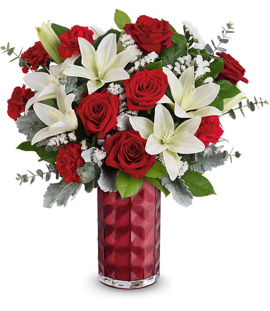 The Floral Harmony Bouquet by Fleuriste Terrafolia Flowers features red roses, red carnations, asiatic and white lilies, plus greenery in a textured deep red Teleflora Love Prism Vase.