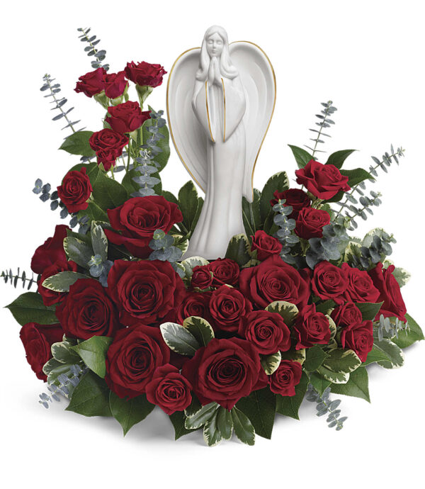 The Forever Our Angel Bouquet by Fleuriste Terrafolia Flowers features a white angel keepsake surrounded by red roses, eucalyptus, and lush greenery for an elegant and striking floral display.