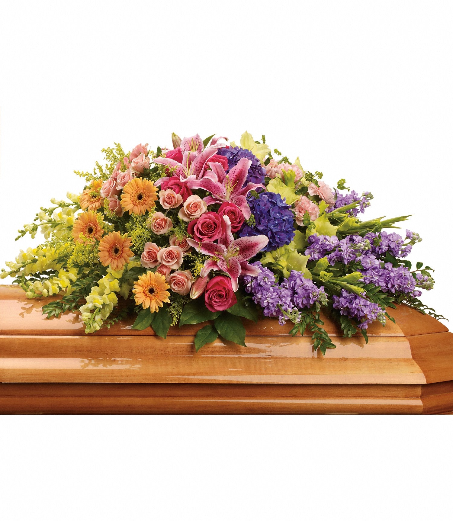 The Garden of Sweet Memories Casket Spray features a wooden casket adorned with pink stargazer lilies, hot pink roses, yellow daisies, purple hydrangea, and lush greenery for a vibrant final tribute.