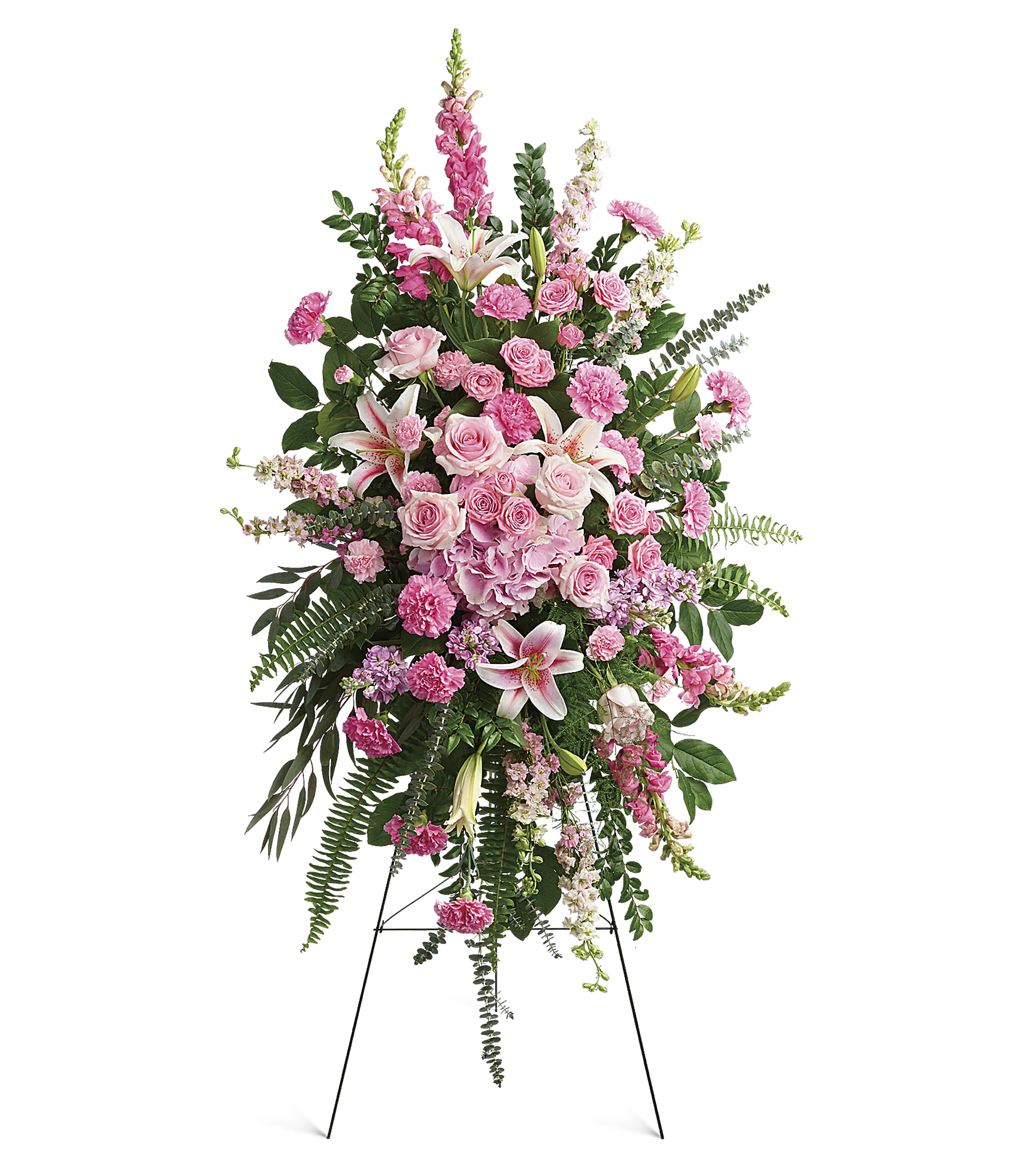 The Glorious Farewell Spray is a pink floral easel arrangement with roses, lilies, carnations, snapdragons, and greenery on a sleek metal stand against a white background.