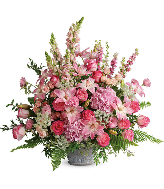 The Graceful Glory Bouquet is a large pink flower arrangement in a gray Parisian Garden Pot, featuring lilies, roses, and snapdragons with lush greenery and ferns in various shades of pink and white.