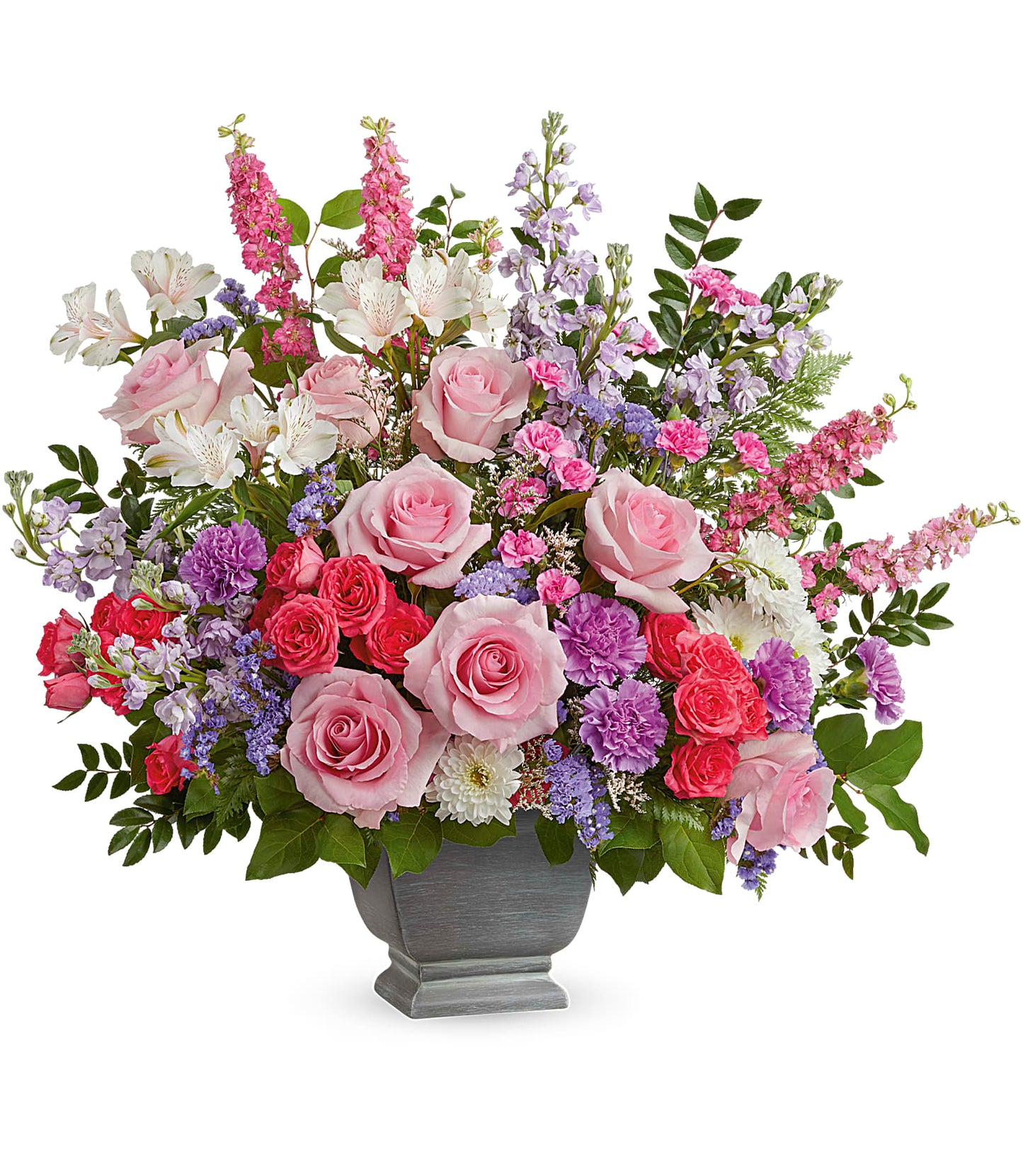 The Love and Light Bouquet in Teleflora's Modern Heritage Pot features pink roses, lavender carnations, purple and white flowers, greenery, and a mix of soft pastel blooms arranged beautifully.