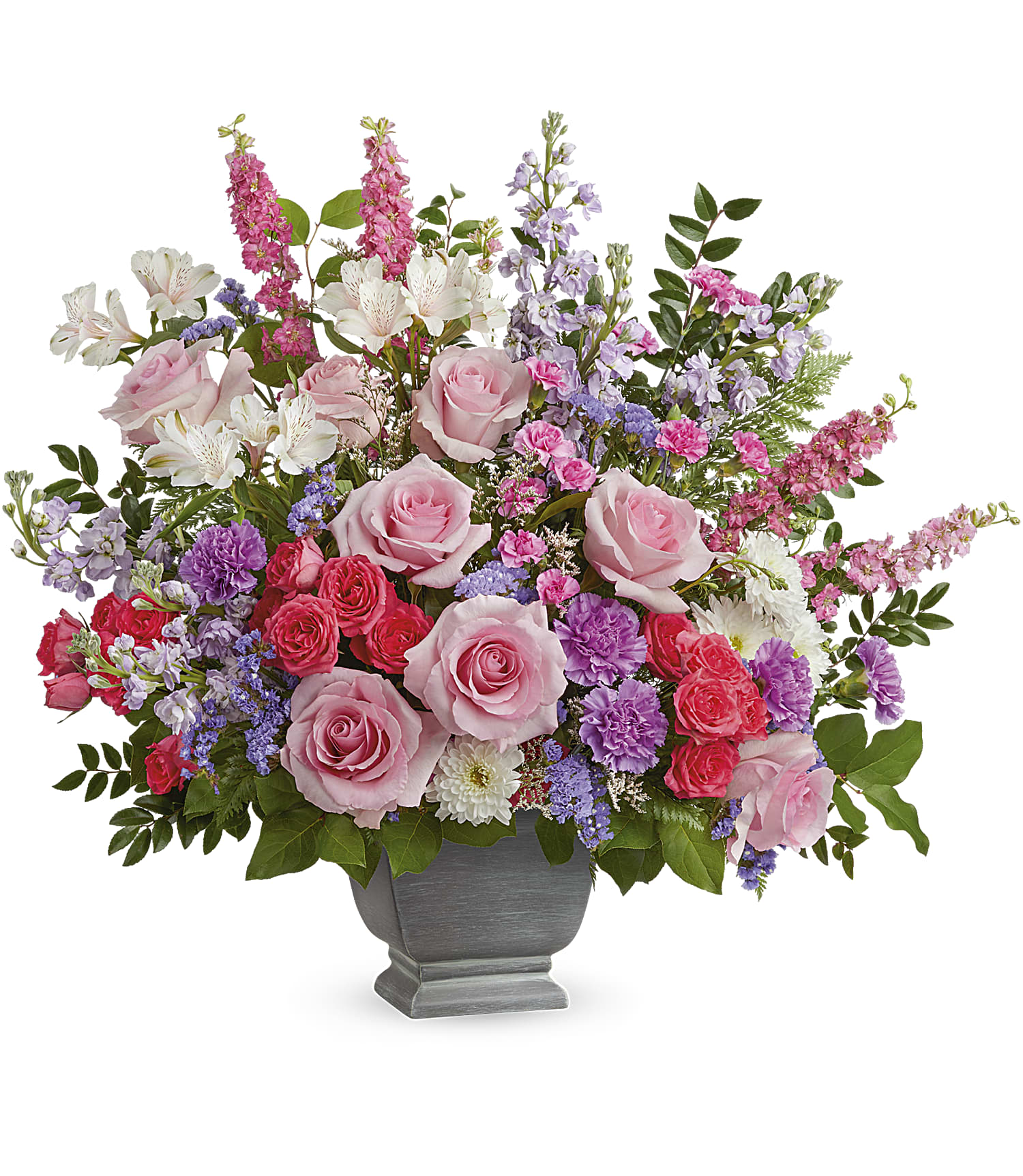 The Love and Light Bouquet in Teleflora's Modern Heritage Pot features pink roses, lavender carnations, purple and white flowers, greenery, and a mix of soft pastel blooms arranged beautifully.