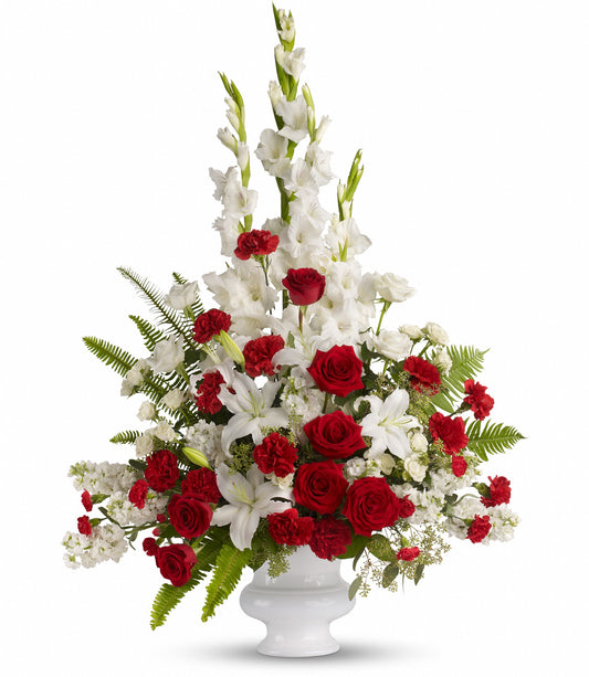 Memories to Treasure floral arrangement in a designer urn featuring white gladioli, oriental lilies, red and white roses, and red carnations accented with greenery.