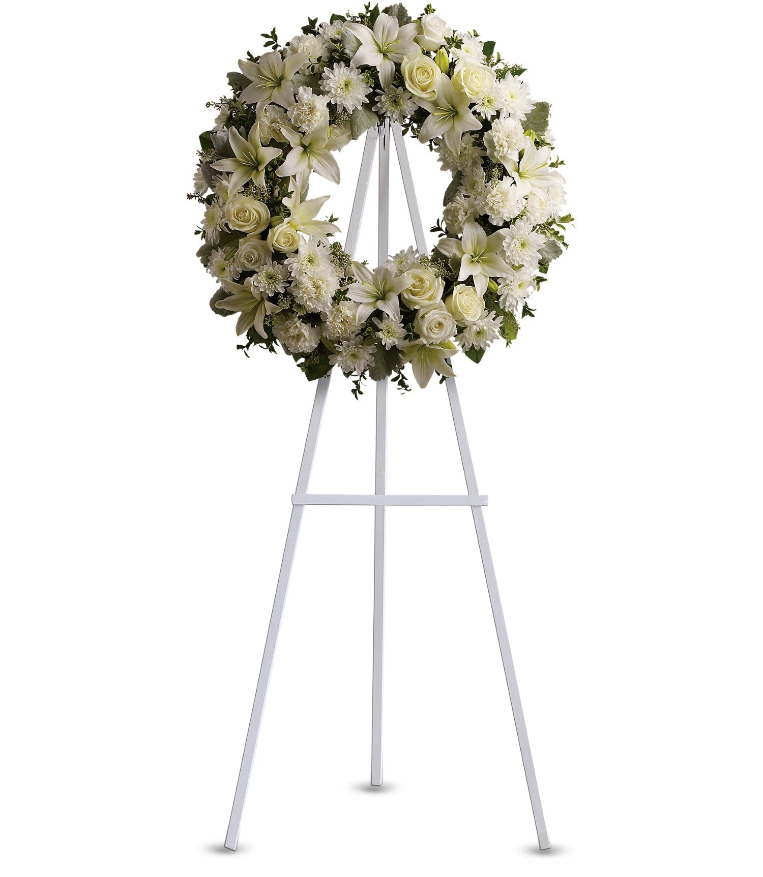 The TF Serenity Wreath, featuring fresh white roses and lilies, is displayed on a tall white metal easel against a plain white background.
