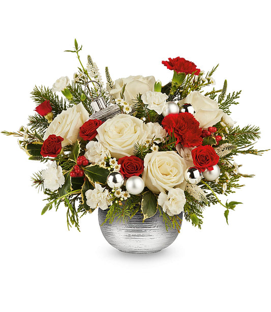 Le bouquet Silver Radiance se compose de roses rouges et blanches, d'œillets et de feuillage, rehaussés d'ornements argentés dans un vase orné de motifs argentés.