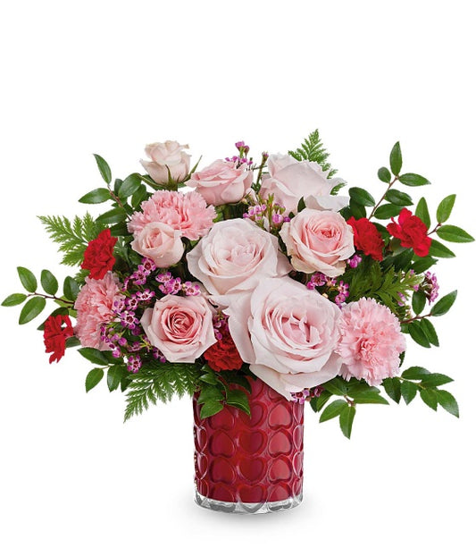 The TF Sweetheart Sparkle Bouquet features light pink roses, pink and red carnations, greenery, and delicate pink spray roses beautifully arranged in our Enchanted Hearts Vase for a romantic touch.