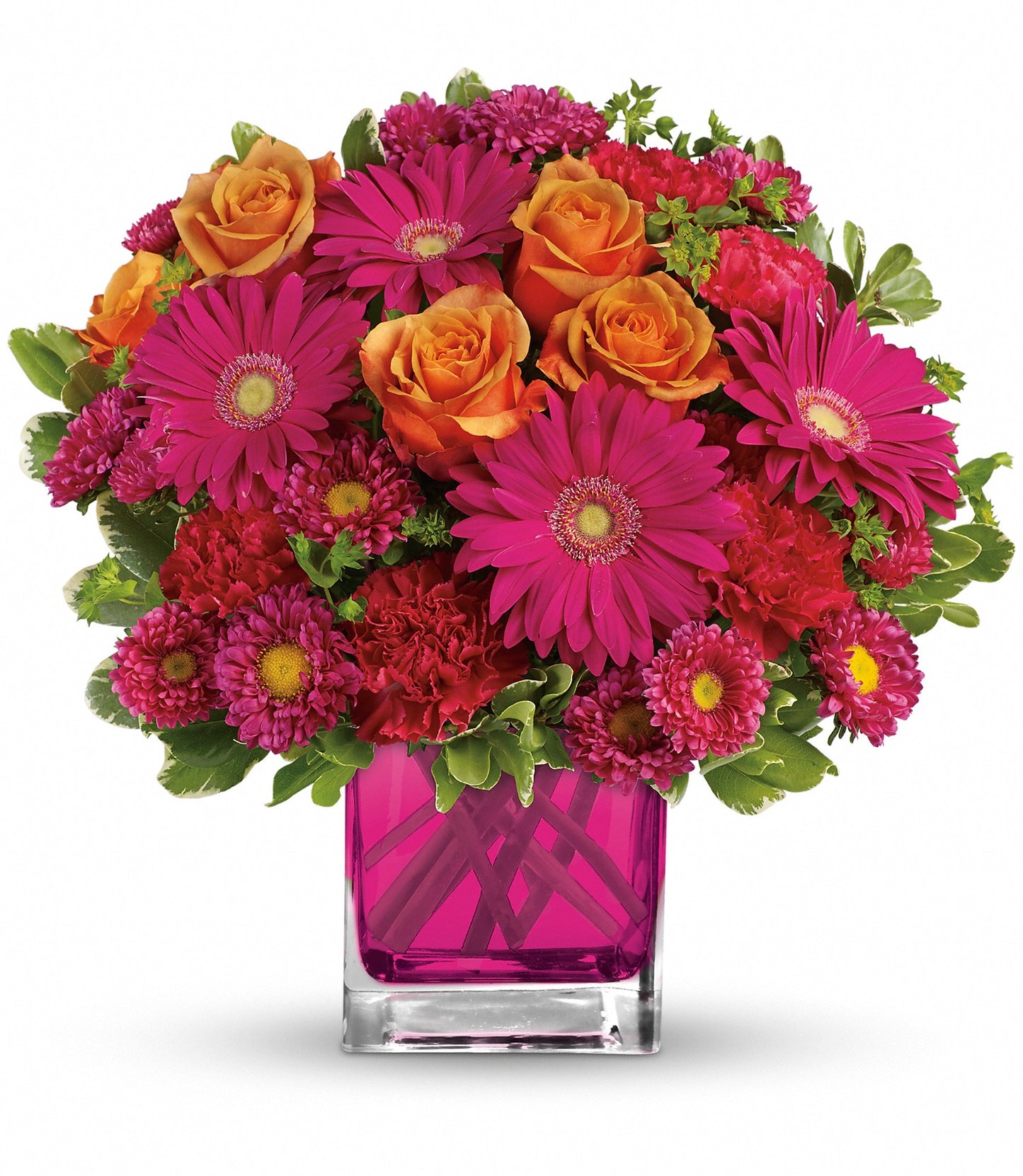 The Turn Up The Pink Bouquet features orange roses and hot pink gerberas with green foliage, all arranged in a stylish square pink glass vase.