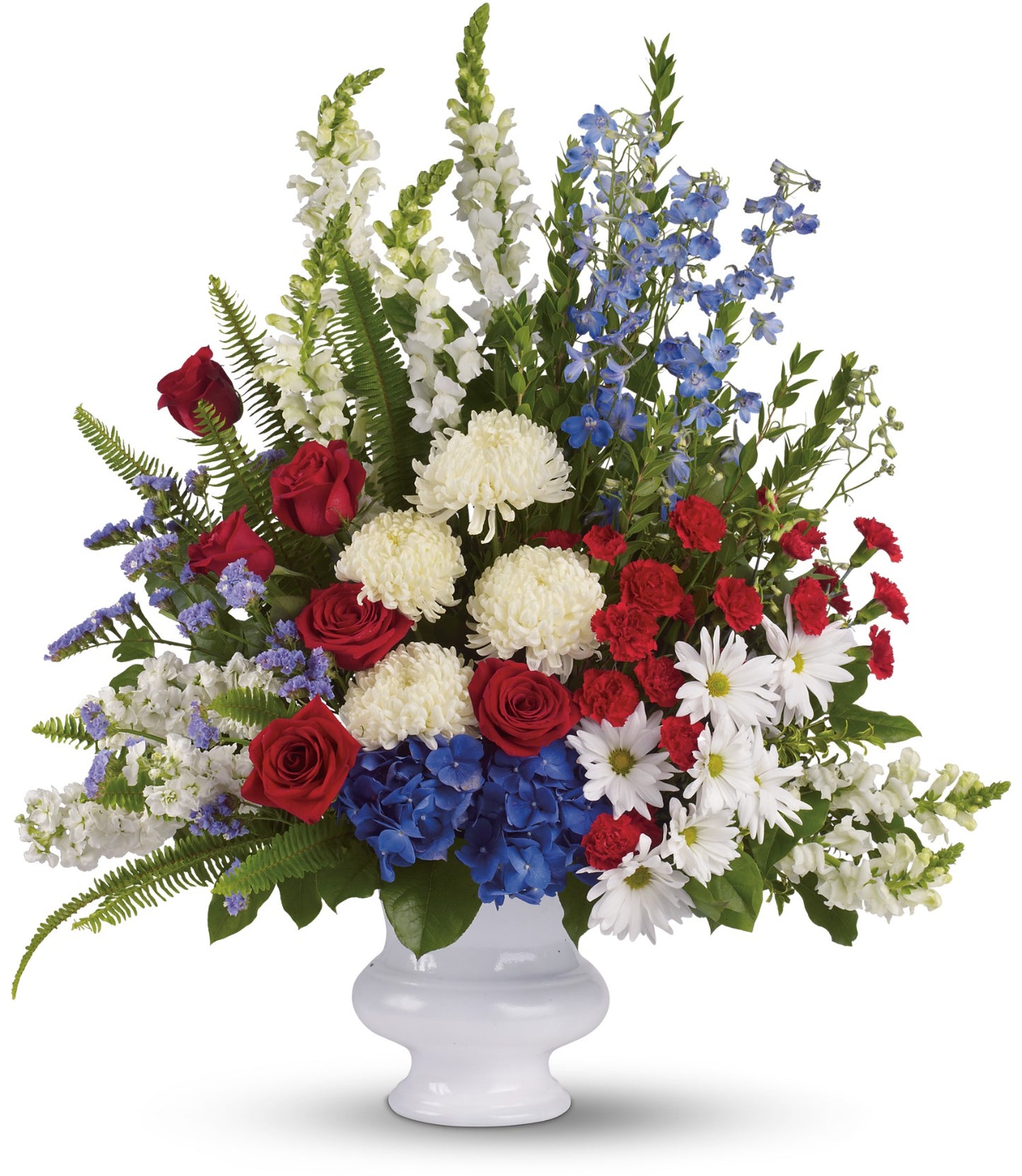 The TF With Distinction features a grand patriotic arrangement in a white urn with red roses, white chrysanthemums and daisies, blue hydrangea, delphiniums, green ferns, and snapdragons in stunning red, white, and blue.