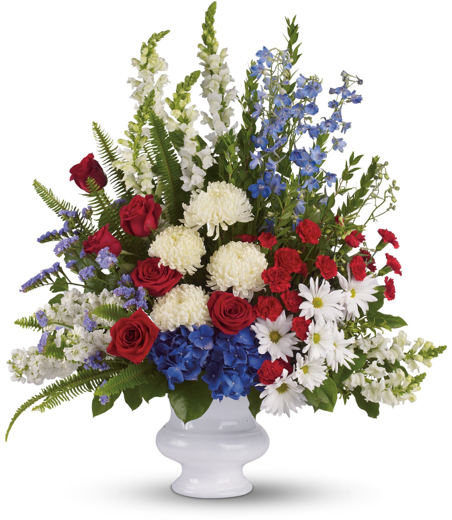 The TF With Distinction features a grand patriotic arrangement in a white urn with red roses, white chrysanthemums and daisies, blue hydrangea, delphiniums, green ferns, and snapdragons in stunning red, white, and blue.